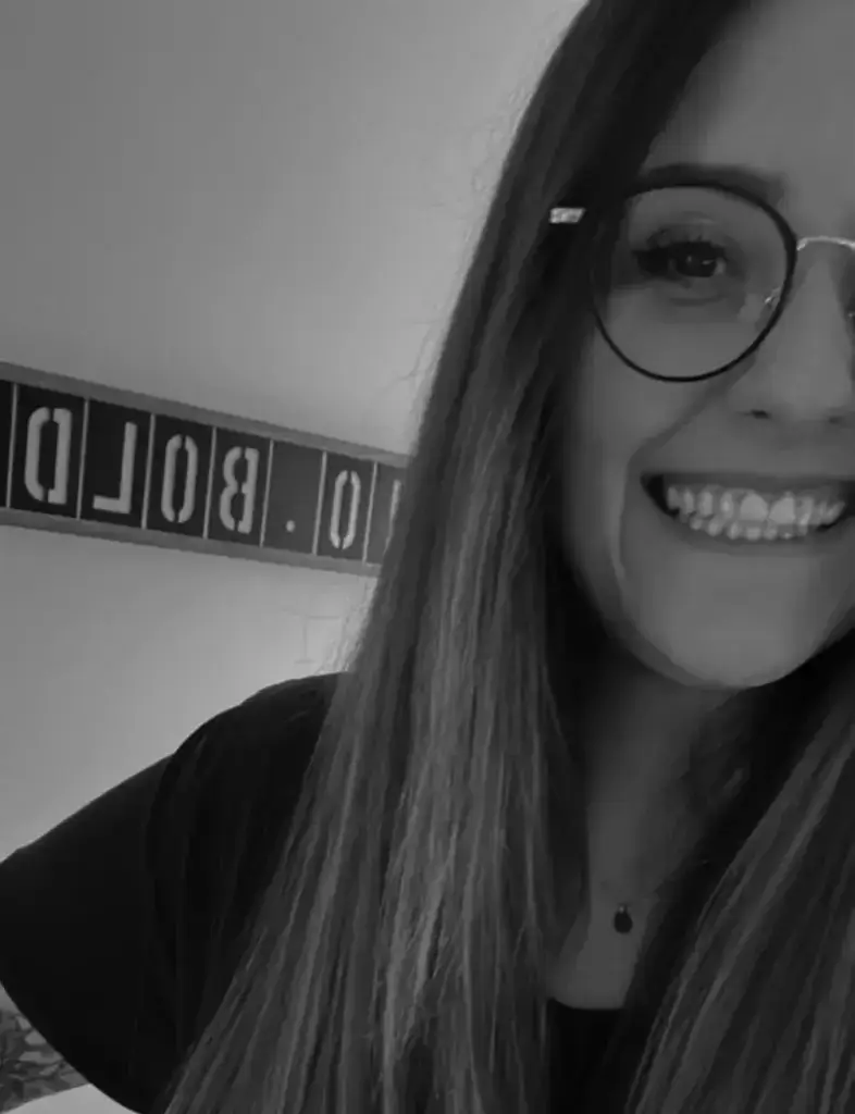 Janine mit Brille lächelt in die Kamera, Schwarzweißbild